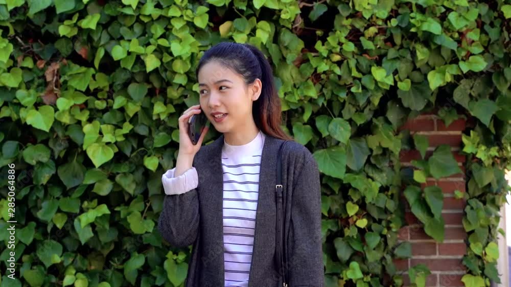 Asian woman talking and laughing on her smart phone. Technology keep in touch people all around the world. Technology lifestyle. Business woman using modern ways of communication. Asian woman talking and laughing on her smart phone. Technology keep in touch people all around the world. Technology lifestyle. Business woman using modern ways of communication.