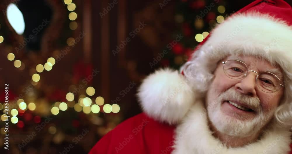 Santa Claus is standing and is laughing in the room decorated for Christmas. Christmas and New Year time. Santa Claus is standing and is laughing in the room decorated for Christmas. Christmas and New Year time.