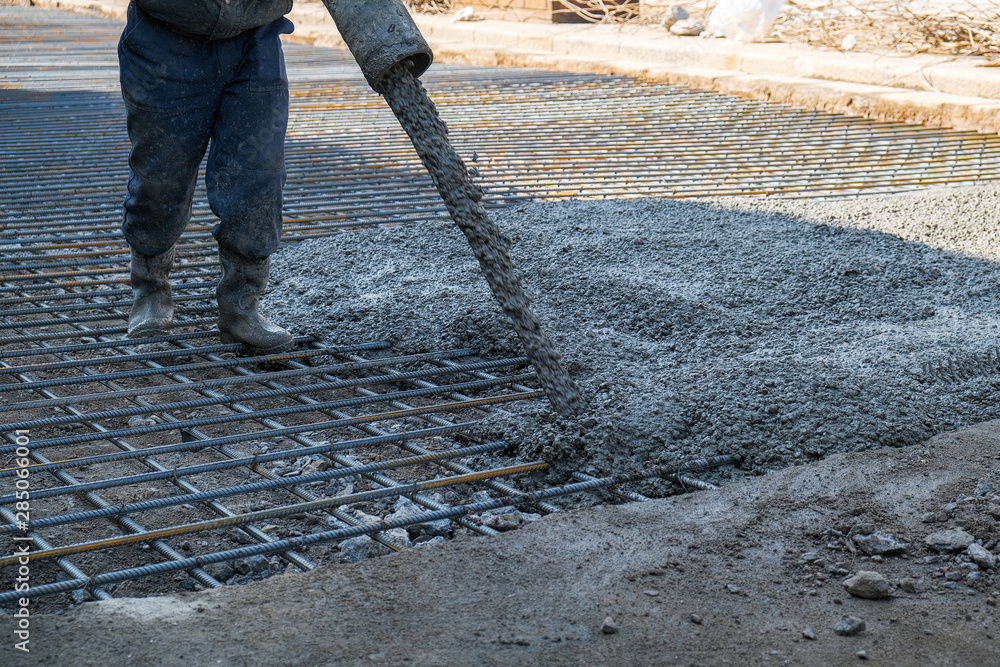 builders poured concrete at the construction site - obrazy, fototapety, plakaty 
