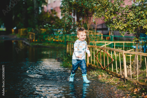 Cute child walking on puddle after a rain