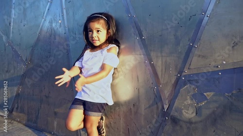 Young Girl Standing Against a Metal Wall photo