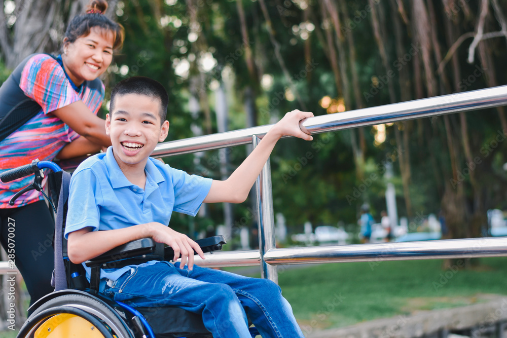 Disabled child on wheelchair is play and learn in the outdoor park like ...