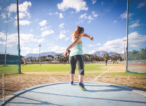 Tableau sur toile Wide angle action photo of a female discus athlete throwing a discus
