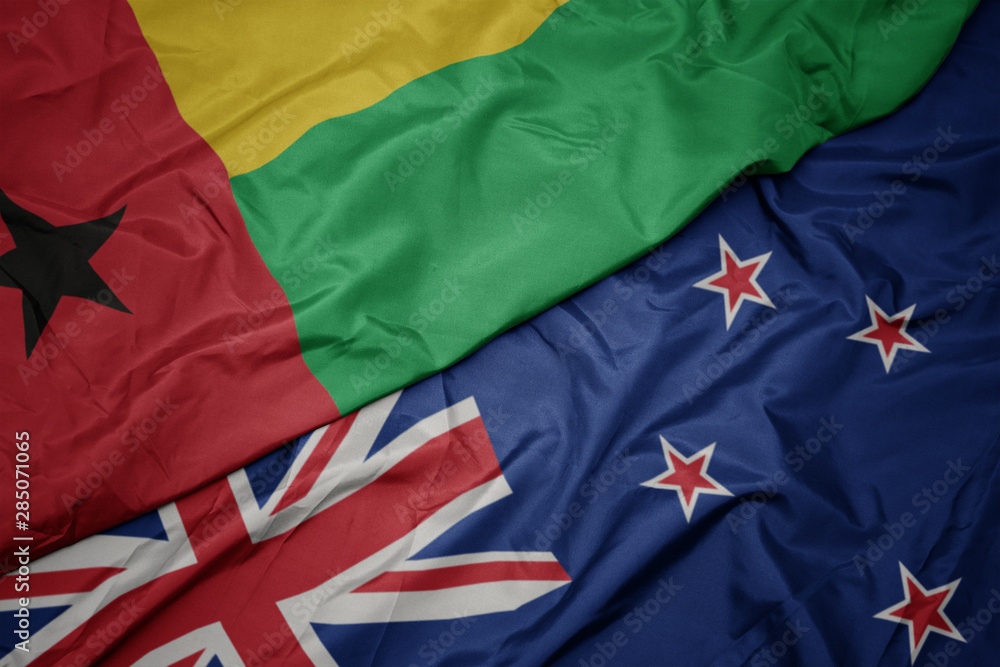 waving colorful flag of new zealand and national flag of guinea bissau. waving colorful flag of new zealand and national flag of guinea bissau.