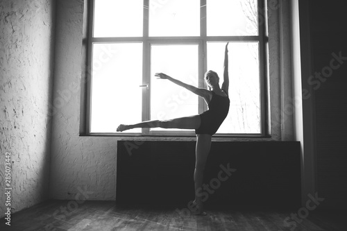 Plasticity slim woman dancing near window. Professional dancer enjoy dance. Lady Dancer Training Modern Ballet In Class. Contemporary dance performer. Daylight, silhouette beautiful body. Dance theme