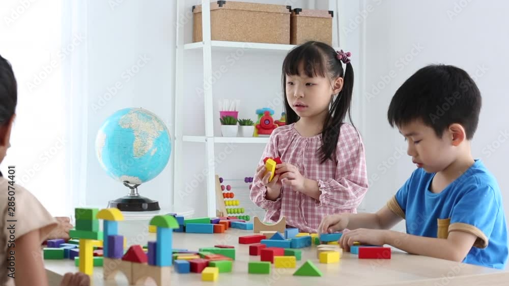 Asian kid boy building house from plastic blocks on table at home shallow depth of field Asian kid boy building house from plastic blocks on table at home shallow depth of field