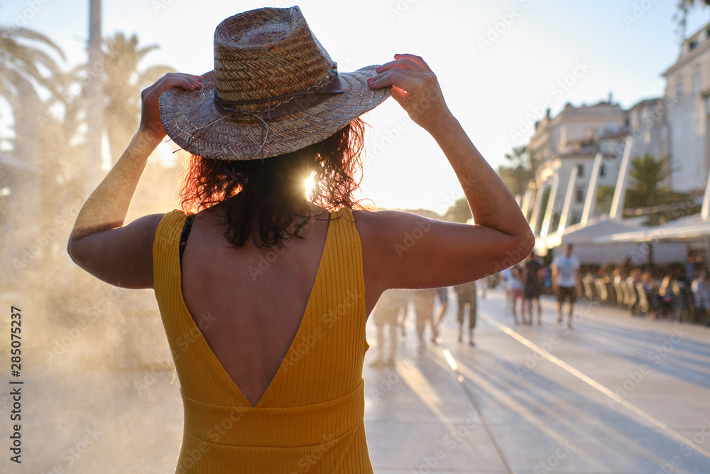 young tourist woman with a hat at sunset in Split, Croatia - travel concept
