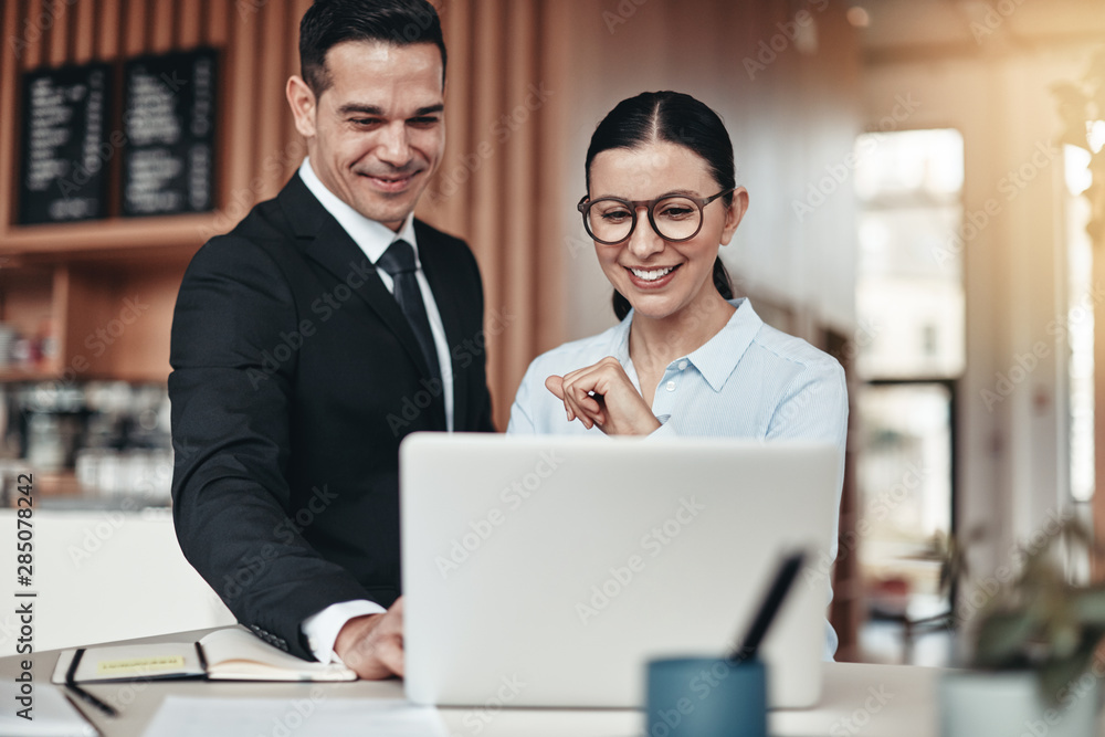 Fototapeta premium Smiling businesspeople working together at a table in an office