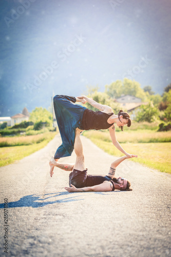  Giovane coppia pratica acroyoga e yoga all'aperto in montagna al parco © phRed