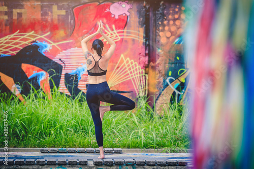 Scenario urbano con coppia di giovani che fa acroyoga e yoga
