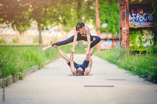 Scenario urbano con coppia di giovani che fa acroyoga e yoga © phRed
