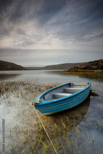 Wide angle landscape image of an old fishing boat in an estuary in South Africa