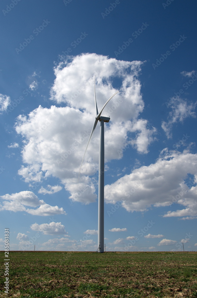 A wind farm in the middle of the steppe in clear weather, against a blue sky.