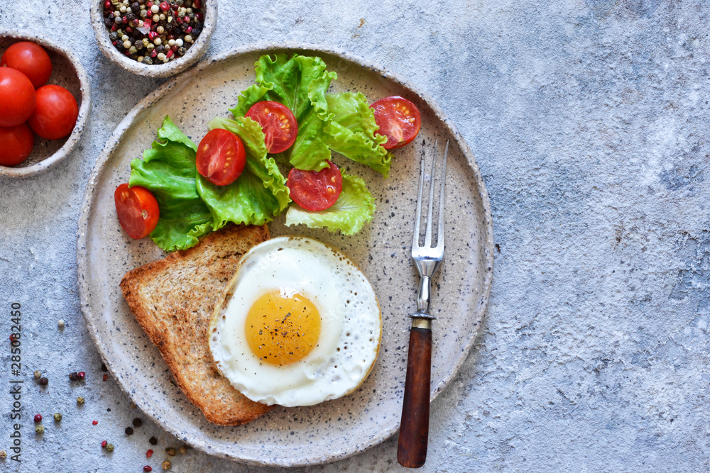 Classic breakfast - bread toast, fried egg and salad. View from above. Good morning. Classic breakfast - bread toast, fried egg and salad. View from above. Good morning.