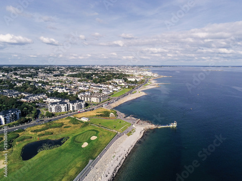 Aerial view on Salthill, Galway city, Ireland, Tilt shift effect, Blackrock diving board, Warm sunny day. People swimming in the ocean.