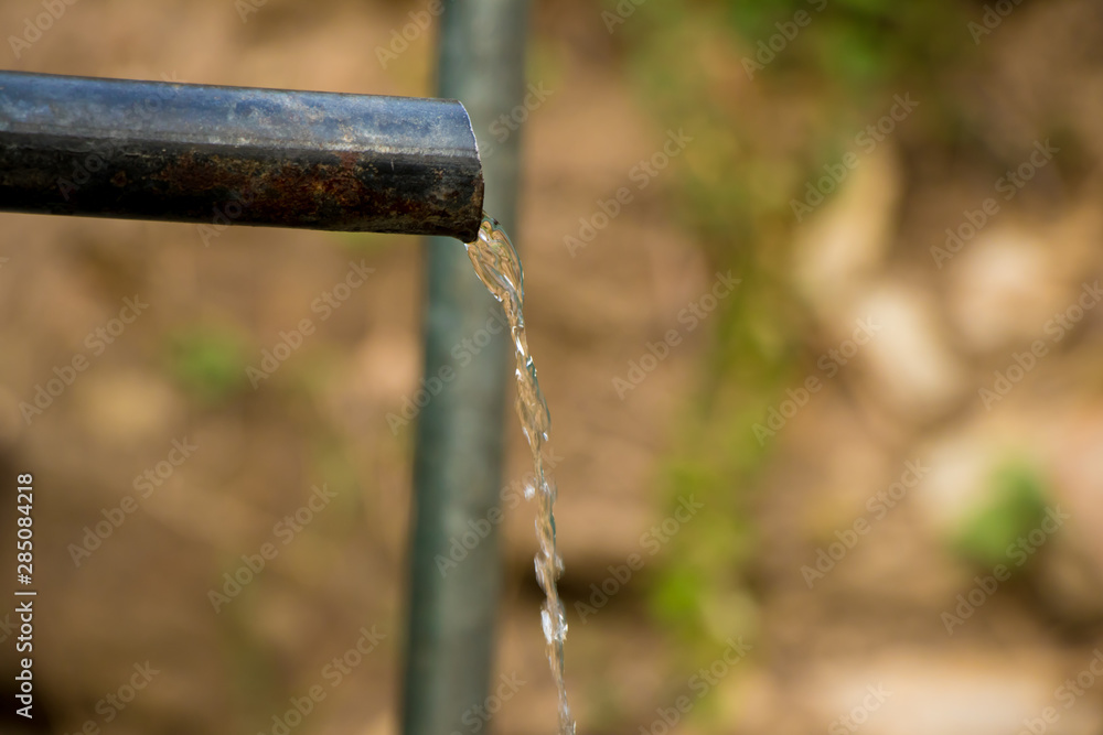 Flowing Water from a tap highlighting the concept to save the water Flowing Water from a tap highlighting the concept to save the water