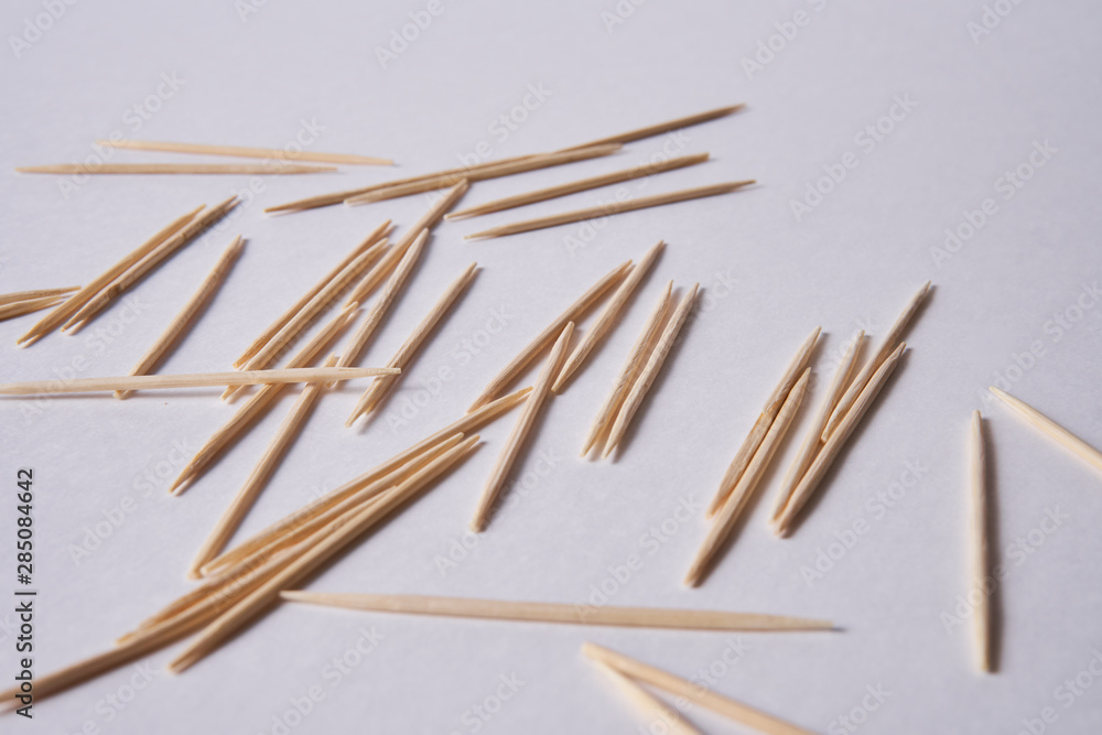 Wooden toothpicks lie in different forms on the table.            