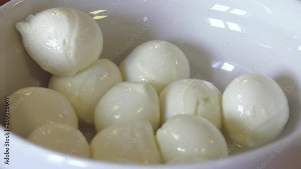 A bowl of small mozzarella balls. Fresh mozzarella cheese - traditional italy dairy product A bowl of small mozzarella balls. Fresh mozzarella cheese - traditional italy dairy product