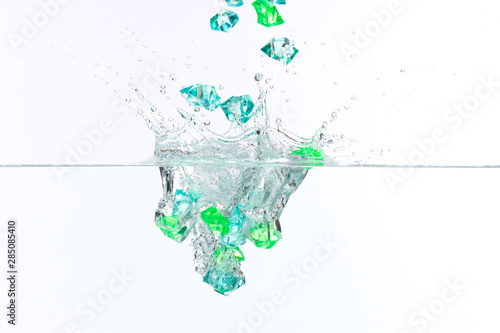 Beautiful and cool splashes of water from falling into it green transparent crystals