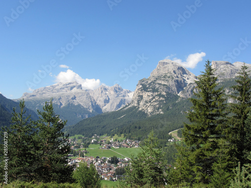 Alpine landscape with La Villa village, green pastures and firs against italian Dolomites at summer . La Villa, Bolzano, Alto Adige, South Tyrol, Italy