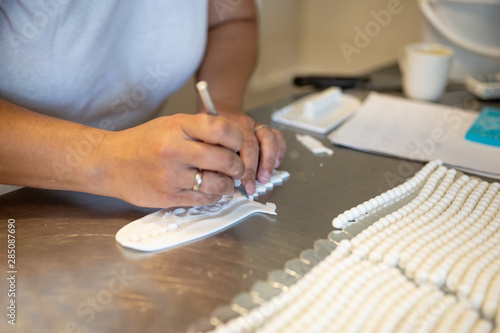 A woman decorates and makes cakes in a pastry shop
