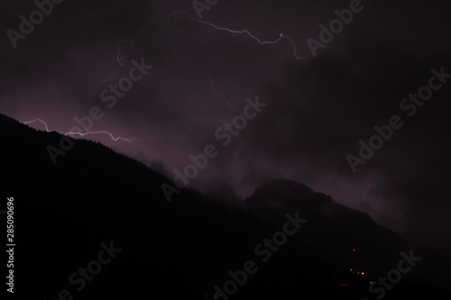 lightnings in the mountains on a black and purple background. Lighting bolt, lightning