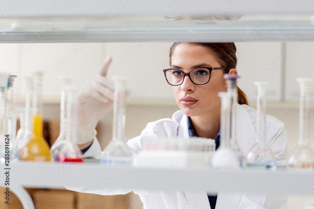Woman in white uniform in laboratory work on analize Woman in white uniform in laboratory work on analize