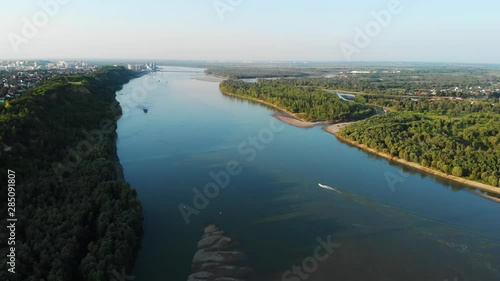 Aerial view of big siberian Ob river and boats in beauty summer day, View to Barnaul city. 4K drone footage.