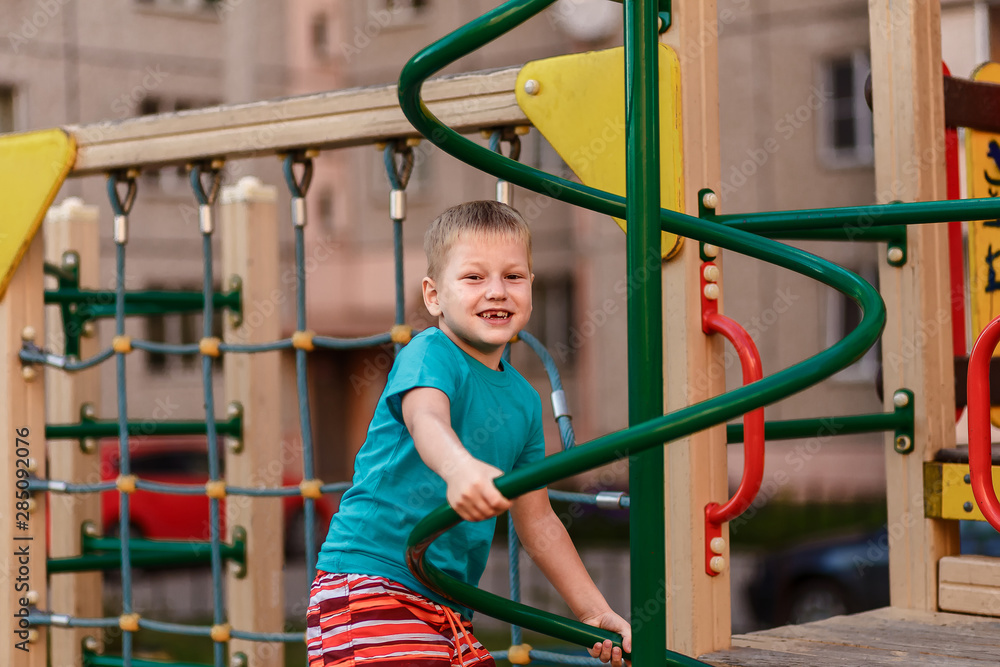 Boy plays in the playground in the summer