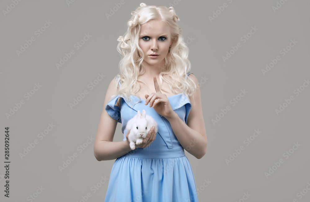 Albino blond girl in elegant dress posing with cute little rabbit Albino blond girl in elegant dress posing with cute little rabbit