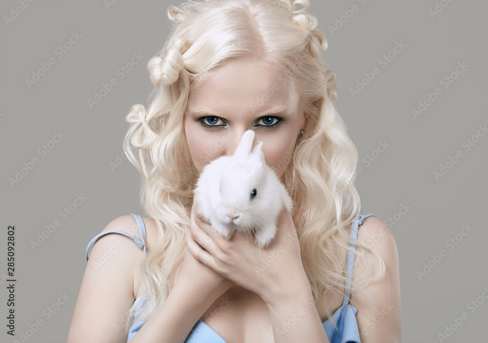 Albino blond girl in elegant dress posing with cute little rabbit Albino blond girl in elegant dress posing with cute little rabbit
