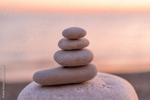 Perfect balance of stack of pebbles at seaside towards sunset. Concept of balance, harmony and meditation. Helping or supporting someone for growing or going higher up.