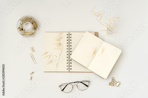 Workspace with blank notebook, dried flowers, elegamt stationery and glasses. Stylish office desk. Autumn or Winter concept. Flat lay, top view. Blogger or freelancer decktop