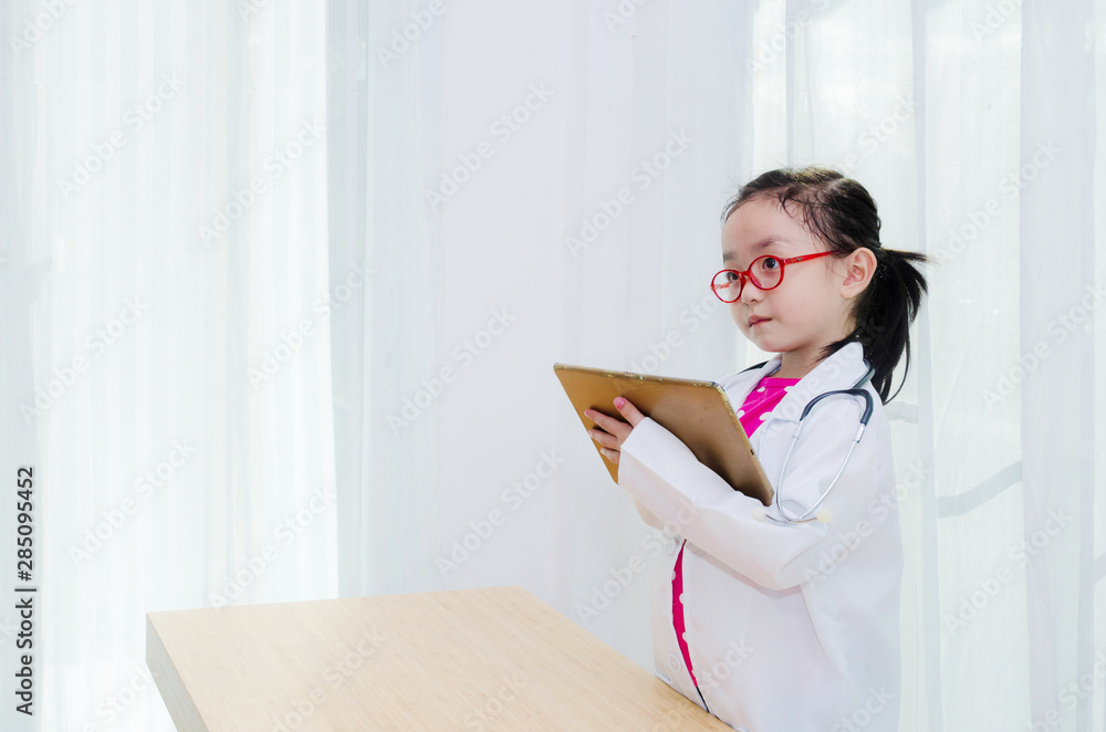 Asian girls wear pink shirts and red eyeglasses.A girl wearing a doctor white dress is holding a smartphone.cute girl. Asian girls wear pink shirts and red eyeglasses.A girl wearing a doctor white dress is holding a smartphone.cute girl.