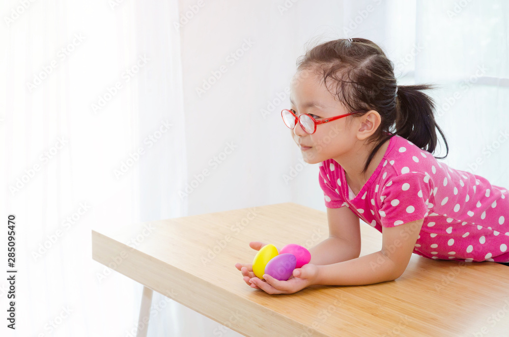 Asian girls wear pink shirts and red eyeglasses.Notebook computer on the wooden table in the room.Do not focus on objects. Asian girls wear pink shirts and red eyeglasses.Notebook computer on the wooden table in the room.Do not focus on objects.