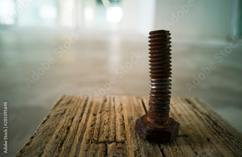 Rusty nut is placed on a wooden floor