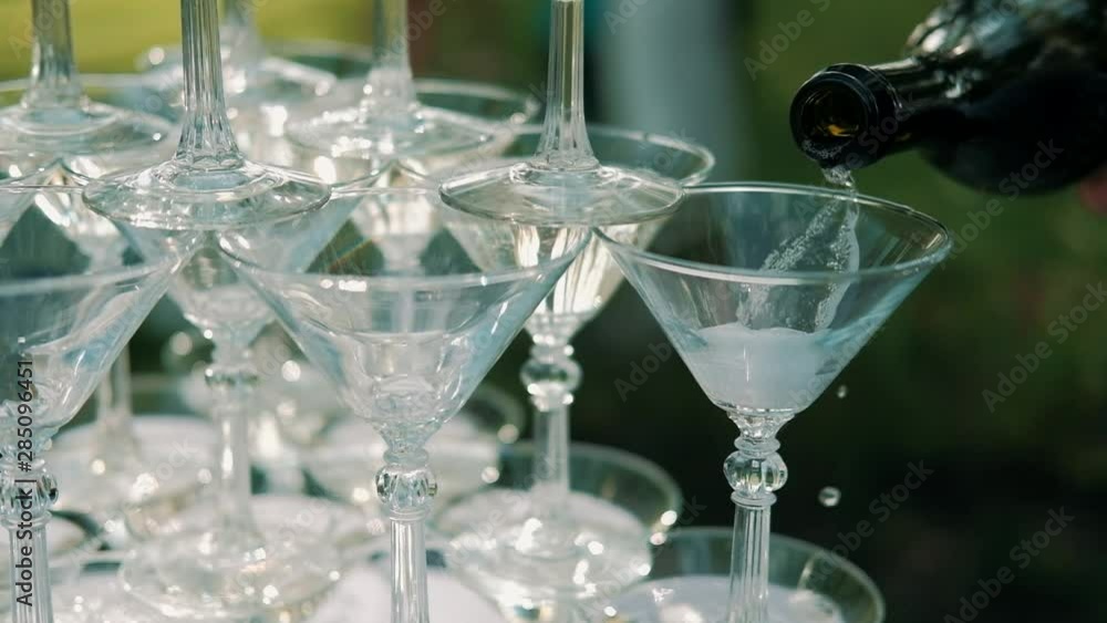 Waiter pours champagne on glasses on wedding outdoors. close up. Waiter pours champagne on glasses on wedding outdoors. close up.