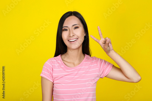 Beautiful young woman on yellow background