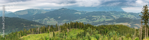 Scenic panorama view of the mountain landscape, forests, pastures, meadows and small villages with a cloudy sky covering the Alps.Department of Haute-Savoie, region of Auvergne-Rhone-Alpes in France.