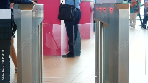 Man in grey suit jacket and blue jeans passing electronic turnstile with barcode scanner. Media. Access control for business center, close-up photo