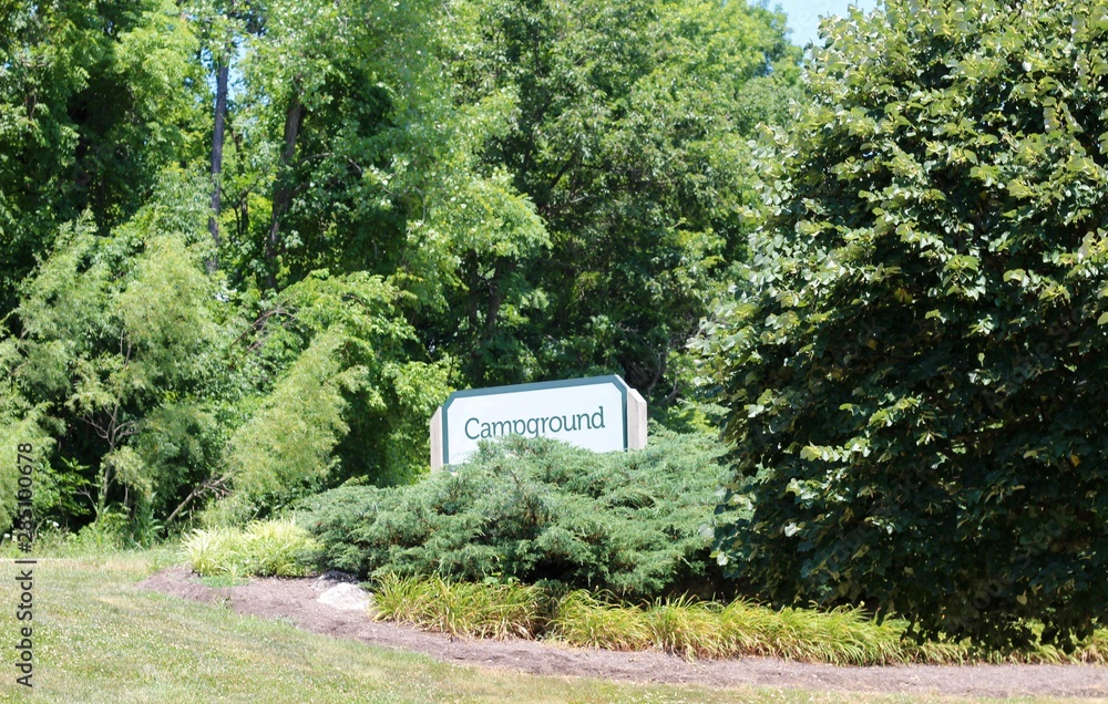 The campground sign on the grass hill on a sunny day. The campground sign on the grass hill on a sunny day.