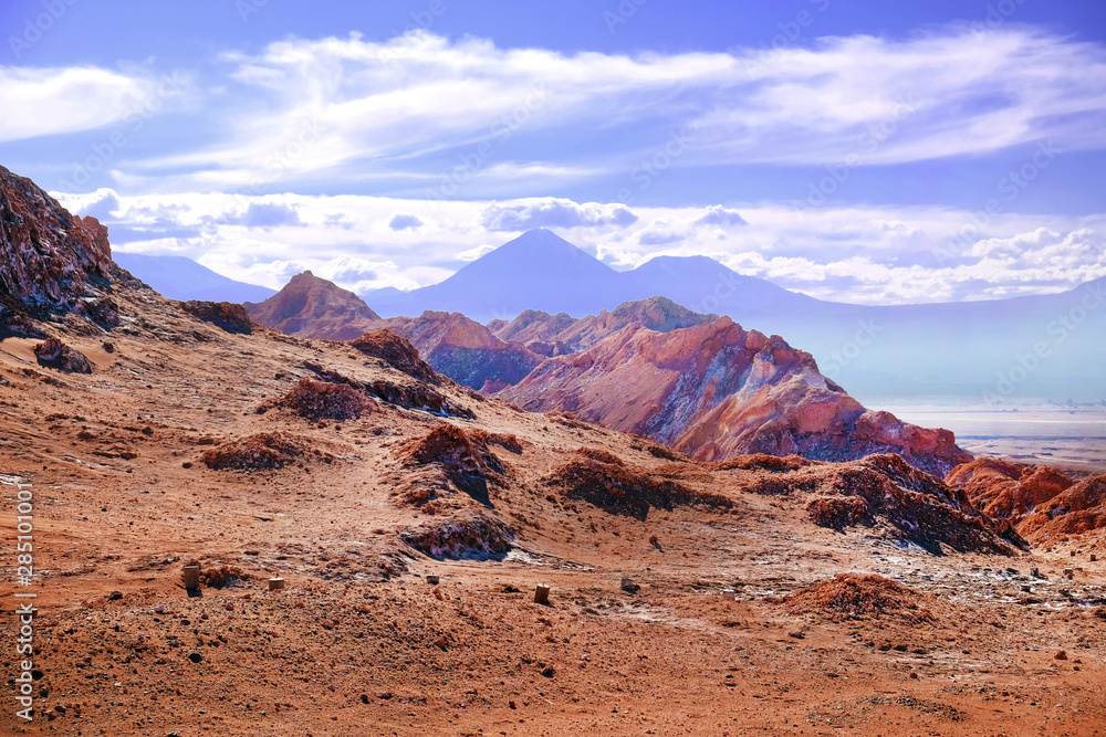 Naklejka premium Desert landscape of the Moon Valley near San Pedro de Atacama, in the northern part of Chile, against a blue sky covered by clouds.