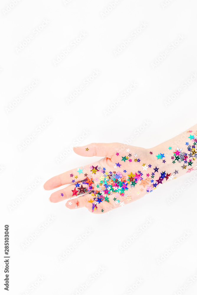 Woman hand with festive color star confetti Woman hand with festive color star confetti