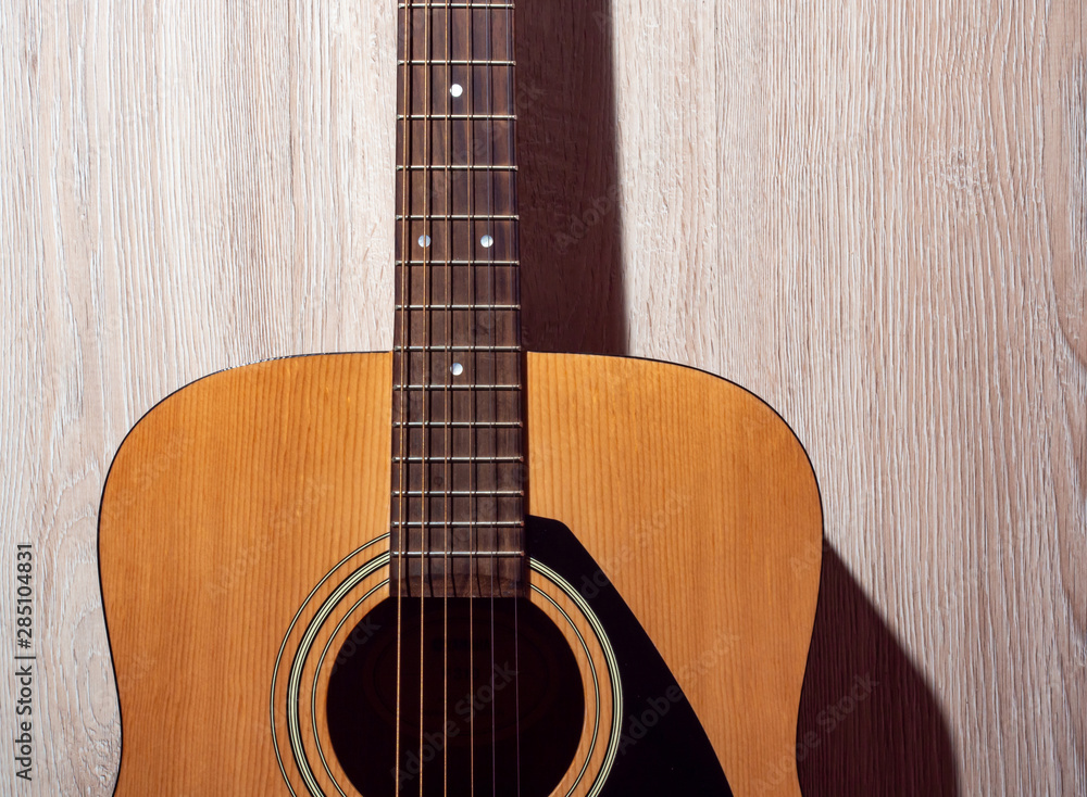 Classical acoustic guitar brown on light wooden background