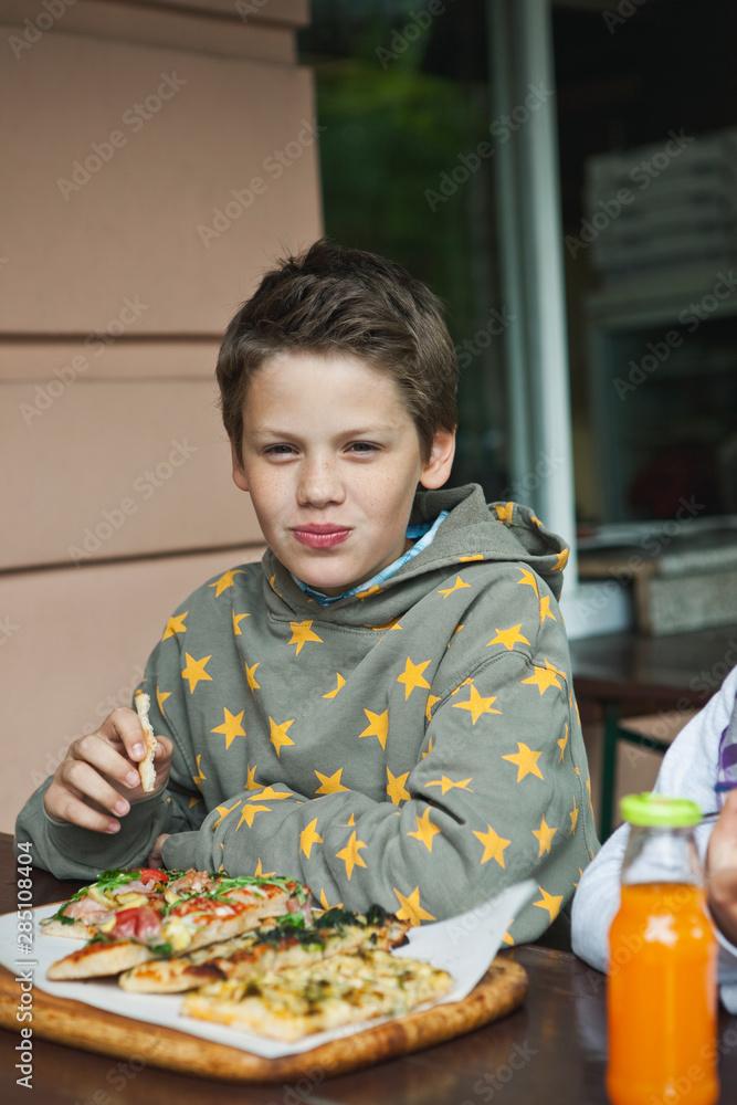 Germany, Berlin, Boy and girl eating pizza at cafe Germany, Berlin, Boy and girl eating pizza at cafe
