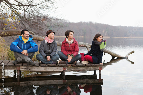 Germany, Berlin, Wandlitz, Men and women sitting on pier photo