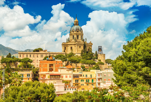 Cityscape of Messina with Cathedral on the top of the hill, colored houses and beautiful clouds with a blue sky, Sicily, Italy