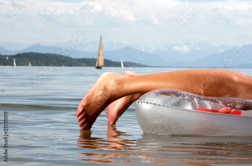 Woman on air mattress lying on front, Lake Starnberg