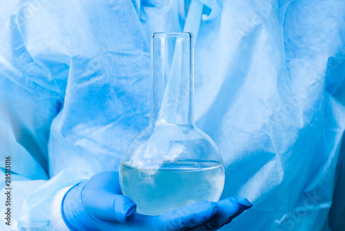 laboratory flask with a liquid in a researcher’s hand