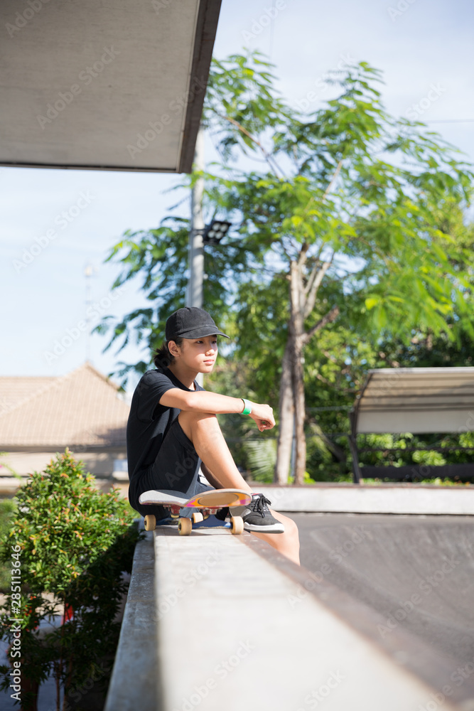 Skateboarder sitting and watching his friends skate Skateboarder sitting and watching his friends skate
